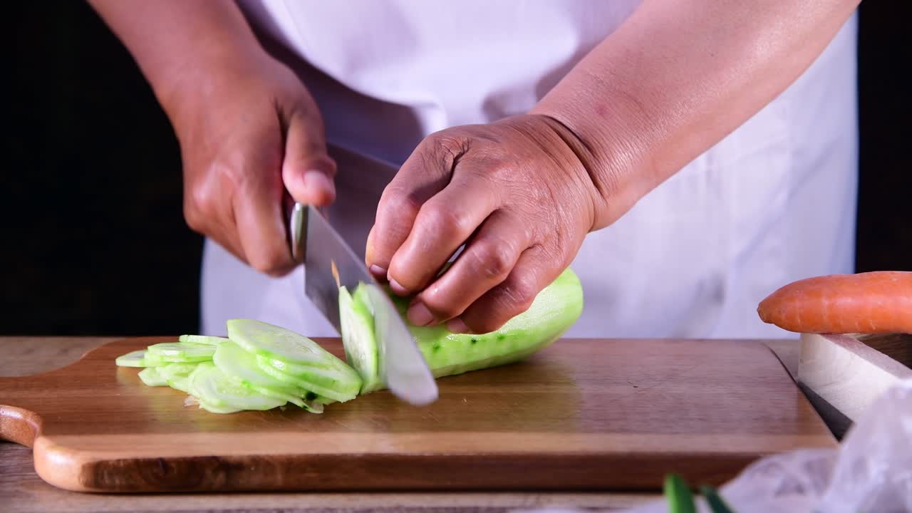 mujer cortando pepino en la tabla de cortar