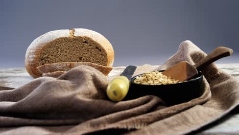 bread loaf with knife and bowl of oats