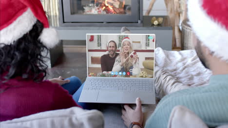 two happy diverse couples having christmas laptop video call, slow motion