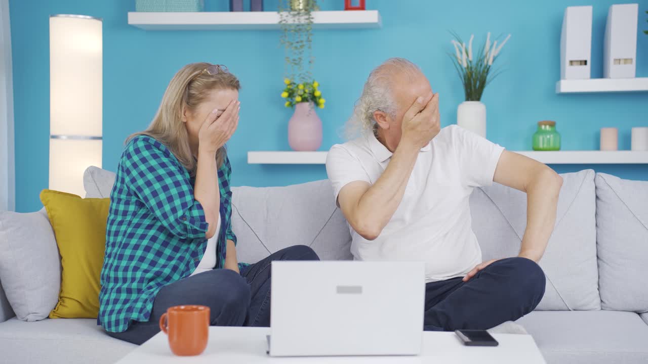 결혼한 부부가 집에서 노트북에서 공포 영화를 보고 있습니다.