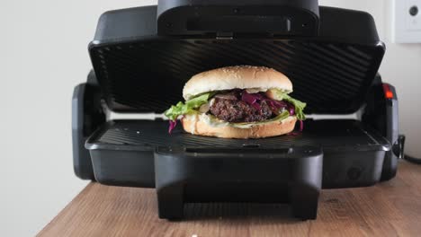 woman cooking a delicious burger in a sandwich press