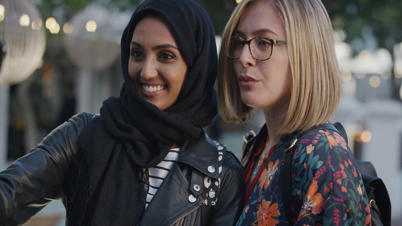 초상화 아름다운 젊은 여성 친구들이 스마트폰을 사용하여 셀카 사진을 찍고 휴가를 즐기는 얼굴을 만들고 다민족 소녀들이 도시에서 휴대전화로 재미를 느끼고 있습니다.