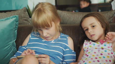 two little girls are tourists waiting for the settlement at the reception of the hotel playing on th