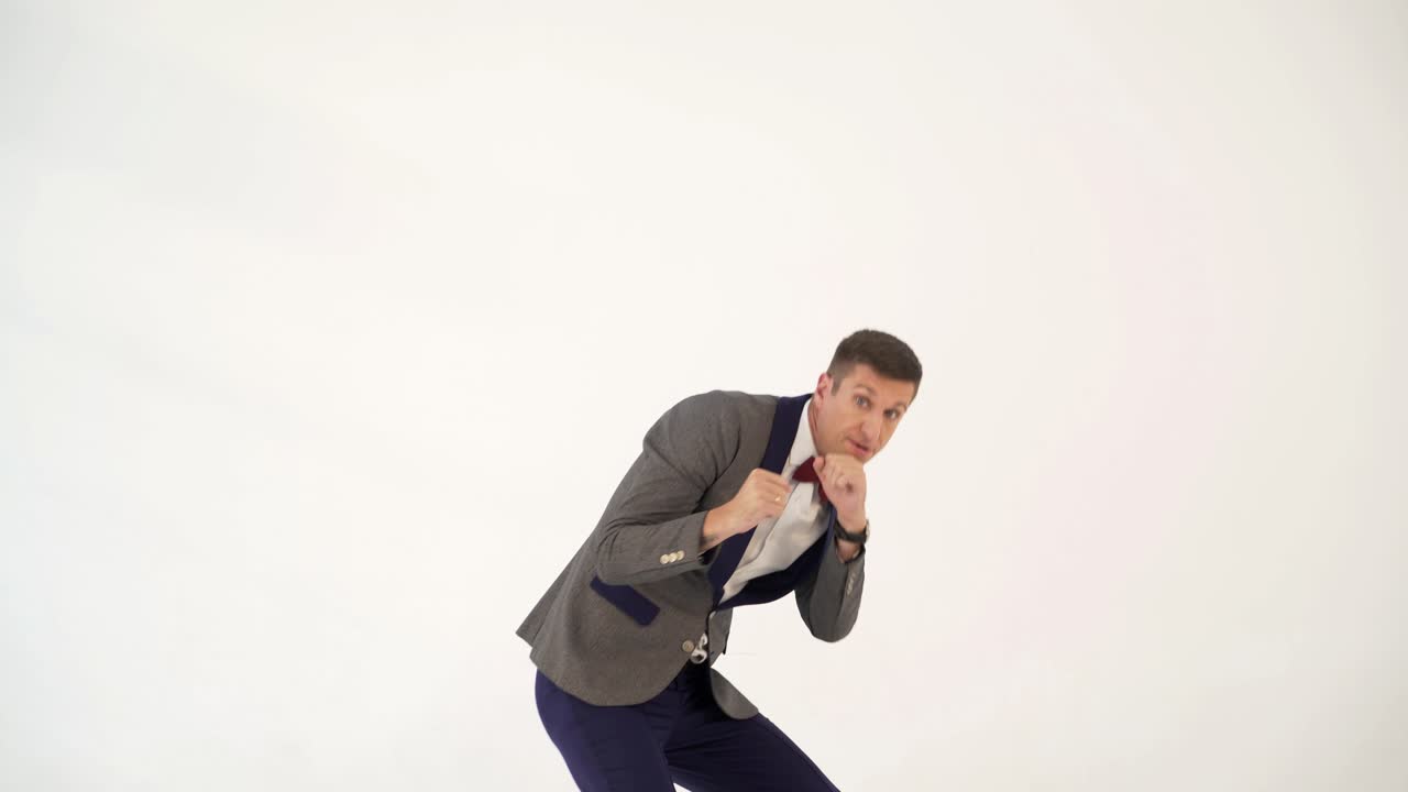 a man in a suit skillfully is copying the movements of a boxer during a fight in the studio. Parody from actor