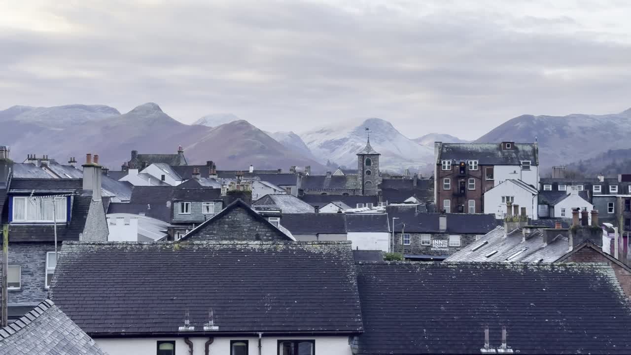 Scenic landscape of Keswick with snowy fells in the background on a quiet winter morning - Lake District, UK