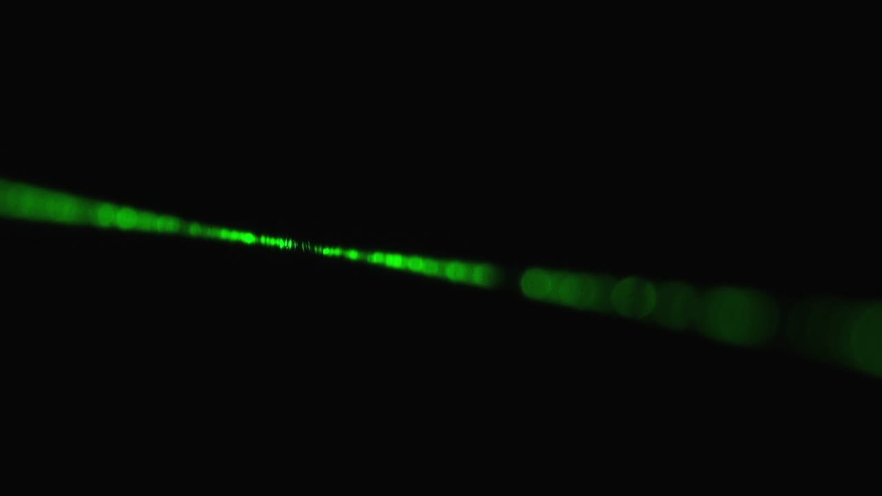 rayo láser verde sobre un fondo negro. rayo láser de potencia que brilla en la niebla