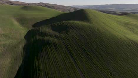 italian rolling green hills at sunset with shadows long aerial pull back establishing shot