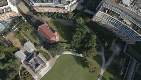 Aerial-bird-eye-top-down-of-apartment-residential-complexes-with-roofs,-garden-and-park-with-green-grass