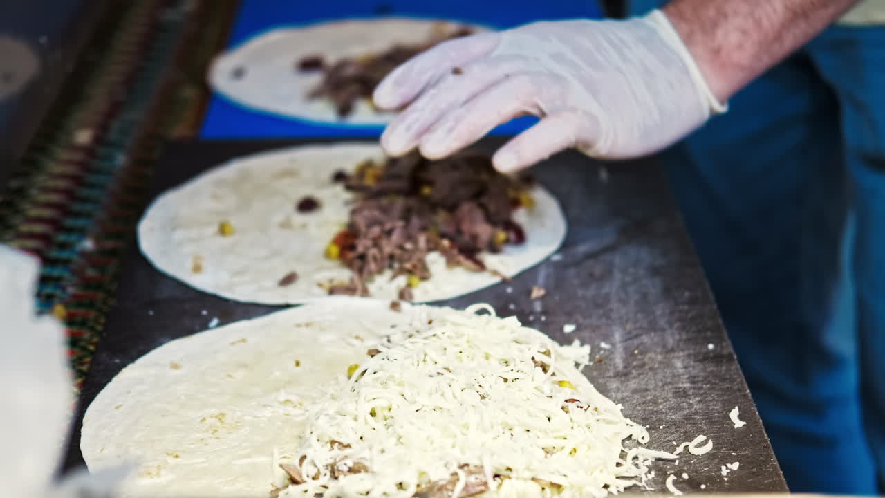 Cook filling flatbreads with ingridients at food festival