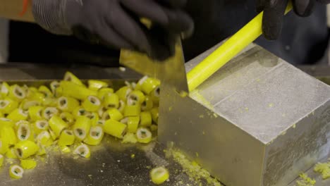 hand chopping yellow pineapple candies