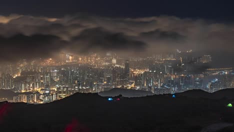 night timelapse with grey transparent clouds flying on dark sky over city lights, cinematic background in tai mo shan, hong kong