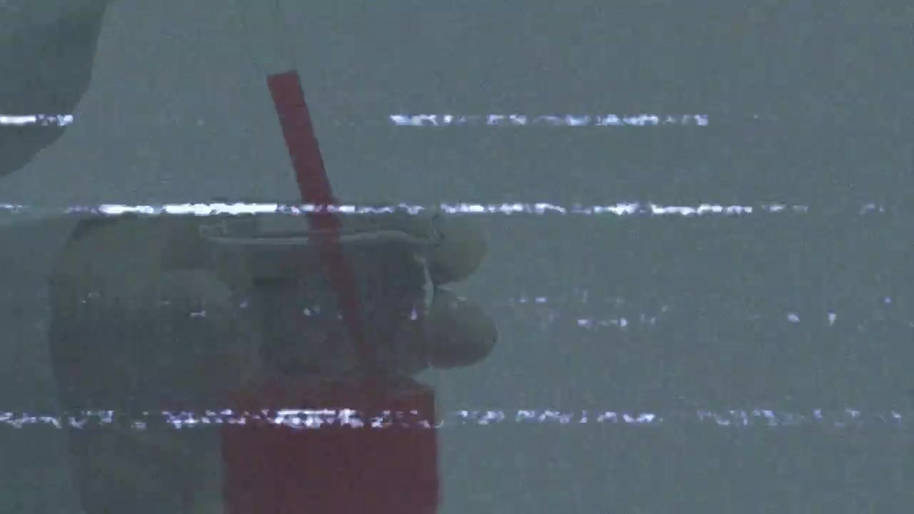 Mani guantate che entrano nell'inquadratura, pipettando una soluzione rossa da una rastrelliera e rilasciando una goccia in una fiala per il riempimento.