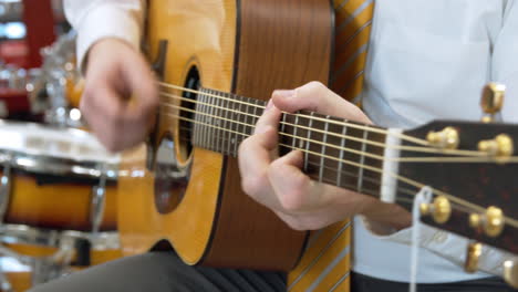 man hand playing a guitar in pawn shop