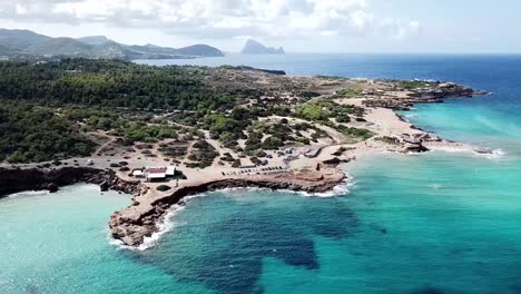 Drone-bird-view-of-Cala-Comte,-one-of-the-most-beautiful-places-on-Ibiza