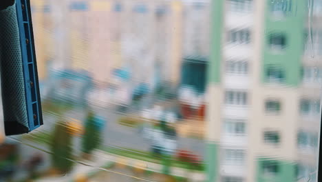 window cleaning brush washing. cleaning window with water and special liquid in the city flat. close-up.