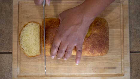 African-American-woman-slicing-homemade-bread,-Overhead-Close-Up-on-hands