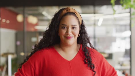 Portrait-of-happy-biracial-businesswoman-looking-at-camera-at-office