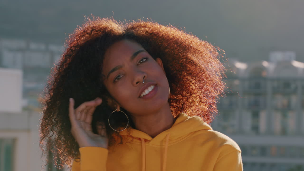retrato de una hermosa mujer afroamericana haciendo caras riendo disfrutando del estilo de vida de verano en el techo al atardecer