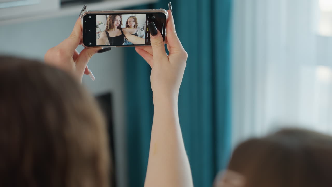 Relaxed Group Capturing Spontaneous Photo, Friends Enjoying Informal Moment With Phone Raised High, Casual Gathering Of Friends Taking Unposed Photo With Cheerful Expressions In Living Room