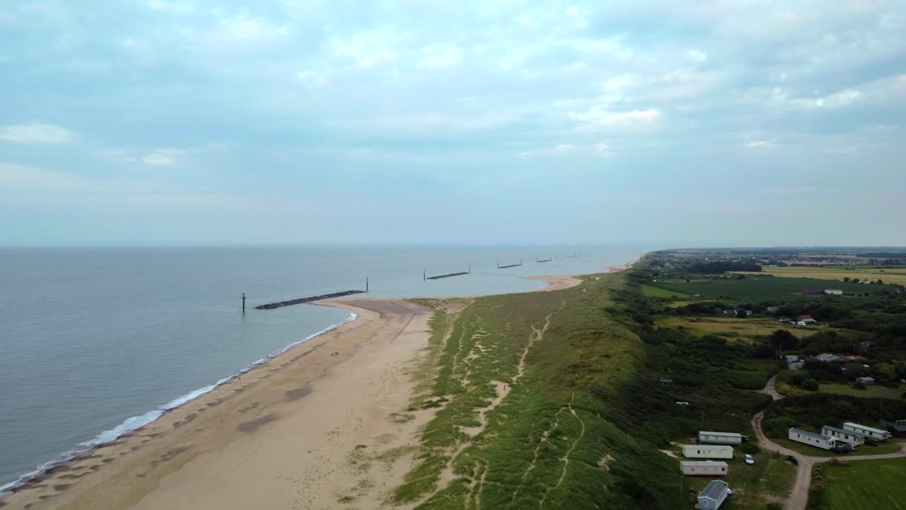 вид с воздуха на пляж с волнорезами в норфолке, англия