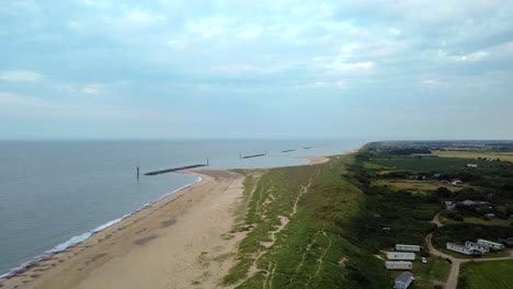 Antena-Sobre-La-Playa-Con-Defensas-Contra-El-Mar-Rompeolas-En-Norfolk,-Inglaterra