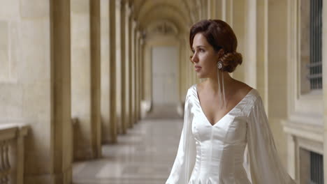 woman in a white satin dress in a parisian colonnade