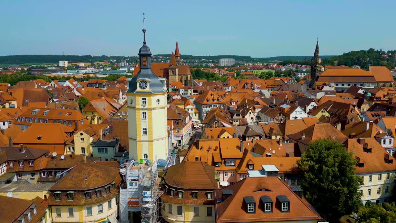 4K Aerial Drone Video of the Clock Tower, St. Johannis Kirche Church, and Kirche St. Gumbertus Church in Ansbach, Germany with Windmill in the Distance
