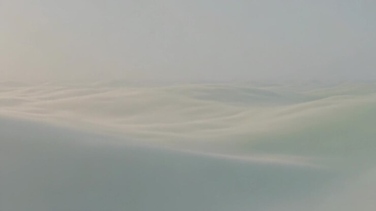 Shifting cloud bank moving across aerial view, showing layered ridges driven by gentle currents