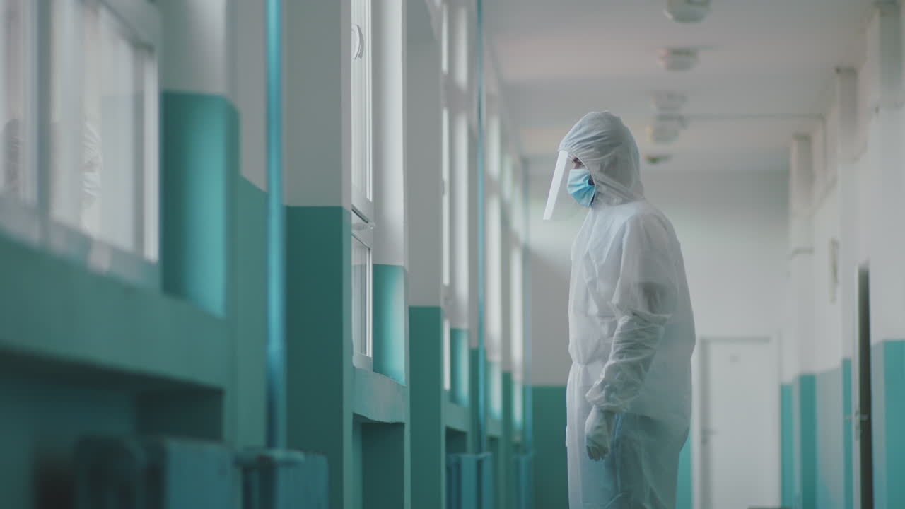 Healthcare worker in protective suit in hospital corridor