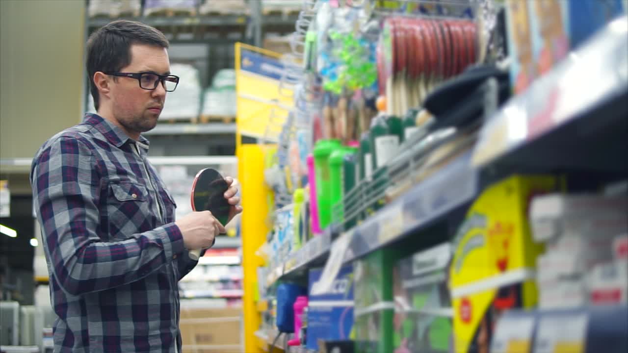 hombre comprando equipos de tenis de mesa en una tienda