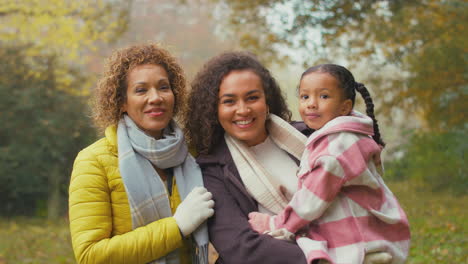 portrait of smiling multi-generation female family walking through autumn countryside together