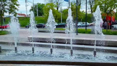 a train with graffiti passes by the fountain in the background