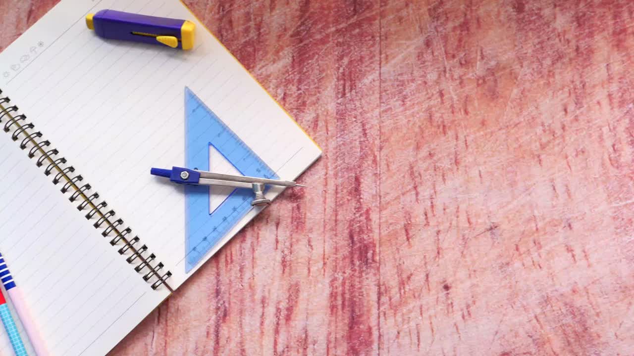 cuaderno abierto con artículos escolares