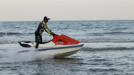 person performing stunts on a jet ski in the ocean.