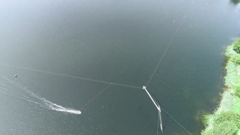 aerial drone shot moving with wakeboarding person at a lake