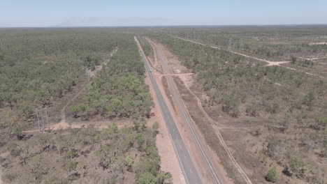 Drohnenaufnahme-Von-Autos,-Die-Auf-Straßen-Und-Eisenbahnen-Im-Nördlichen-Territorium,-Outback-Australien,-Fahren