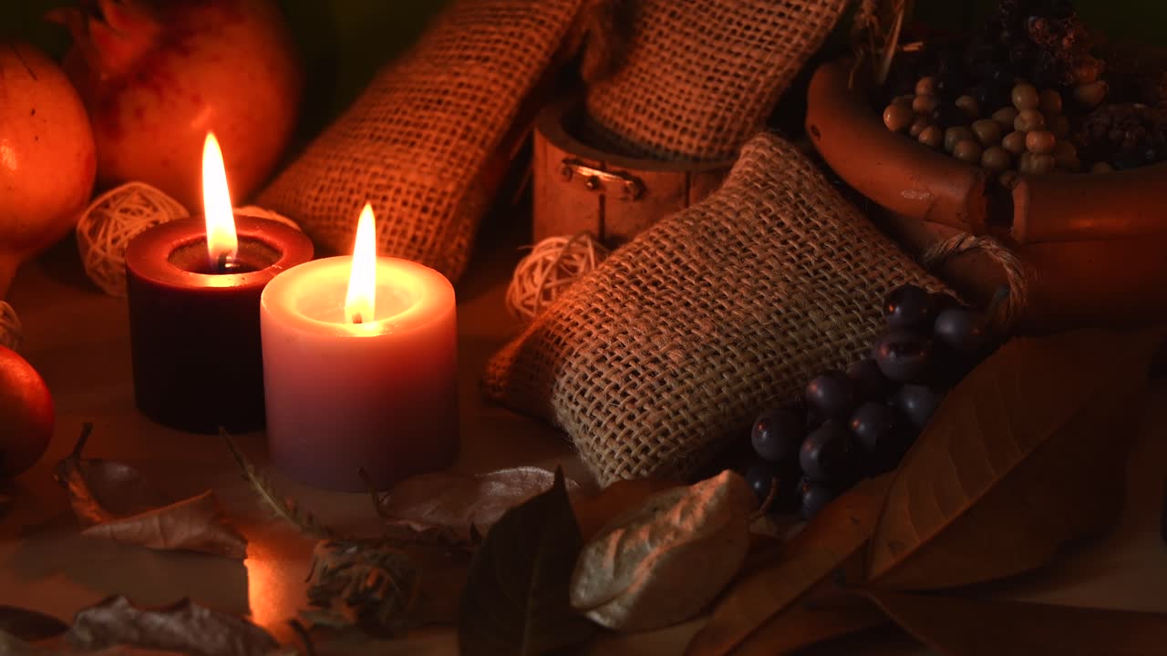 acogedor fondo otoñal con granadas, uvas, hojas secas y velas