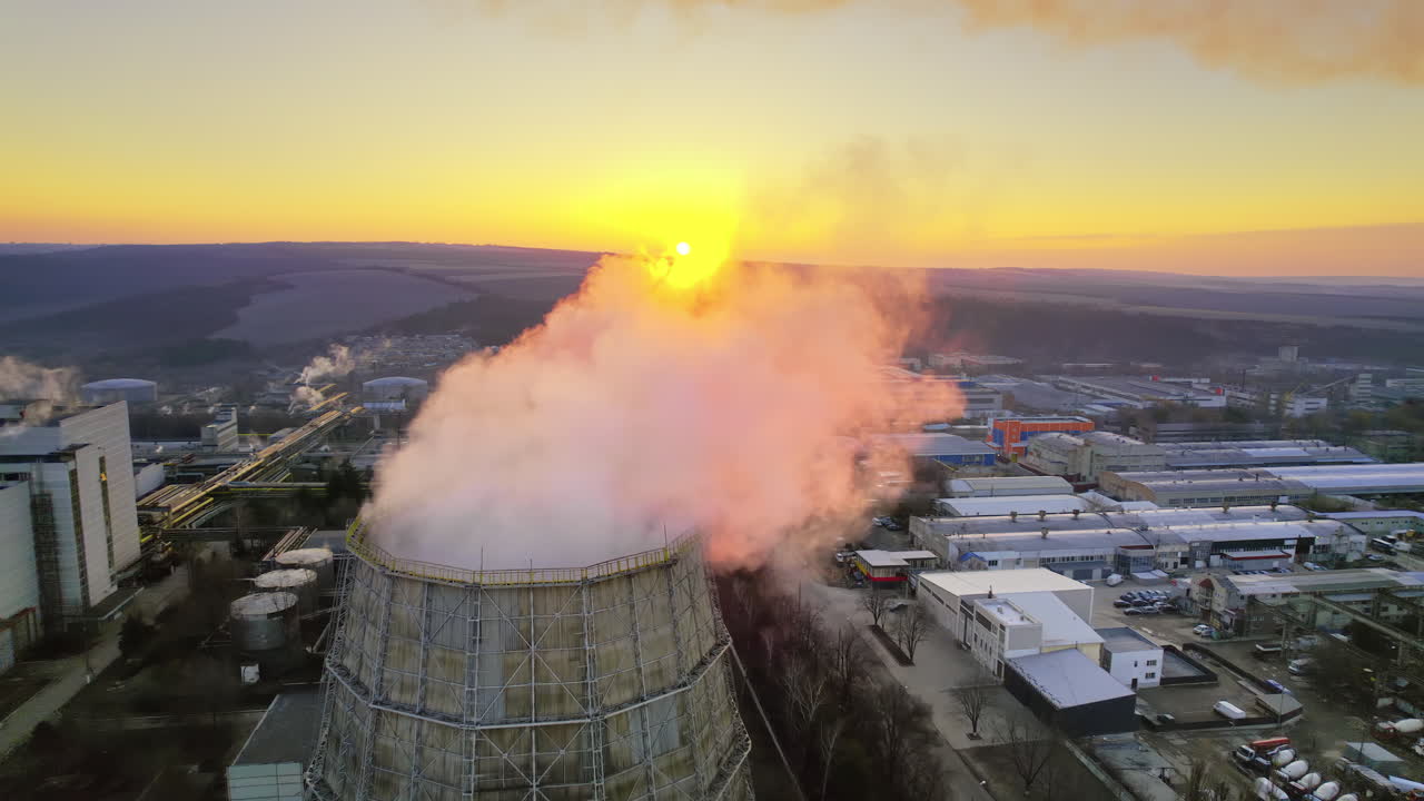 Paesaggio industriale con torri di raffreddamento e tramonto