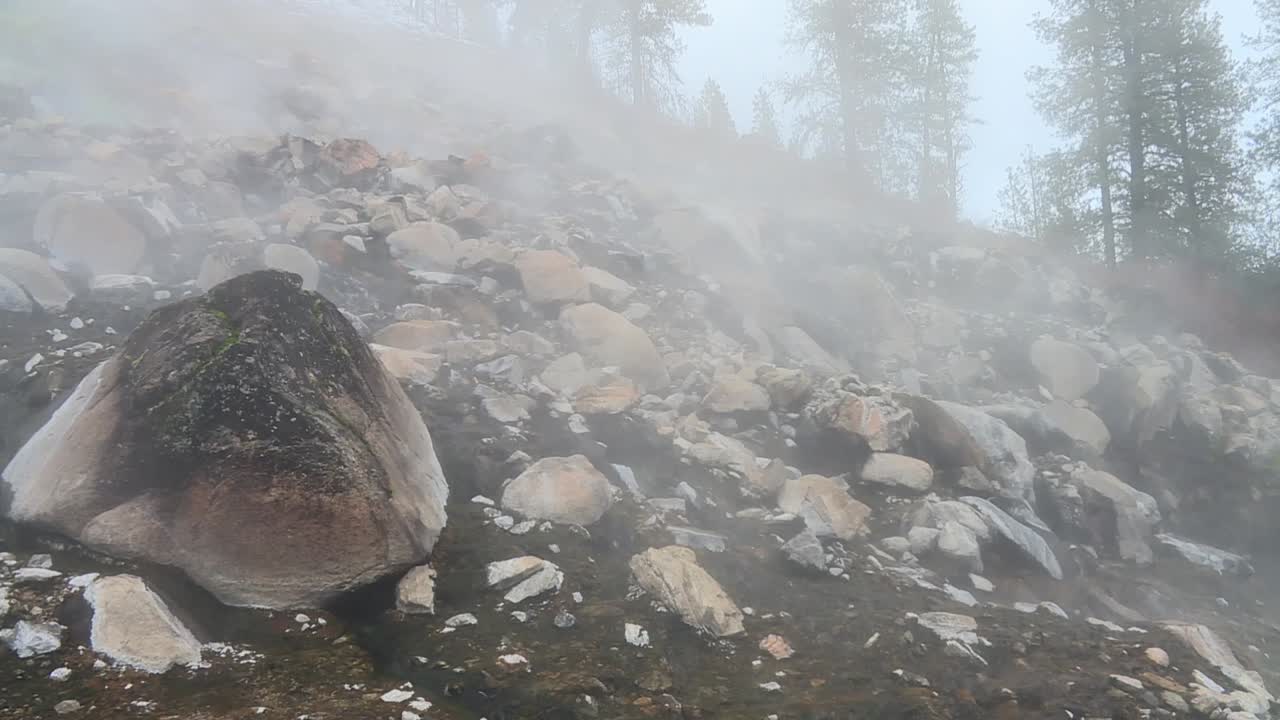 тусклые облака разбросаны по скалам в горячей источнике горной реки в бойзском национальном лесу, айдахо, сша