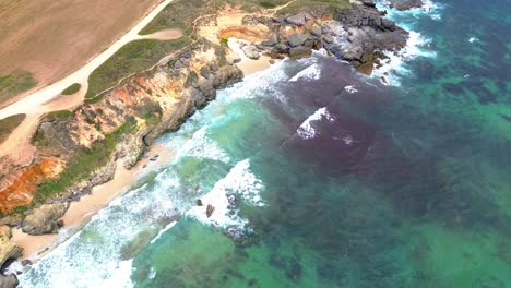 Vista-Aérea-De-La-Costa-Escarpada,-Olas-Azules,-4k