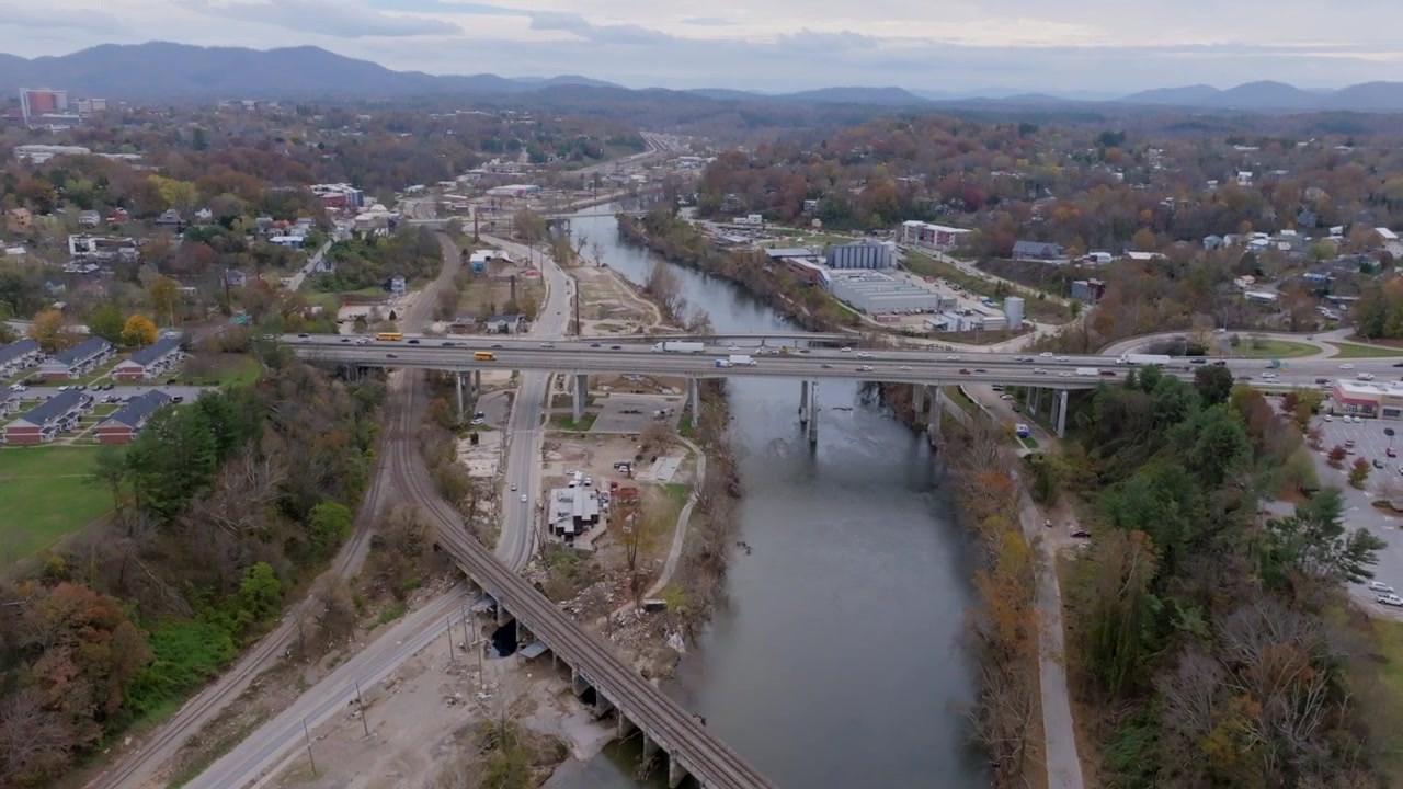 Riprese aeree sul fiume French Broad ad Asheville, NC, con panoramica verso l'alto per rivelare l'autostrada I-240.