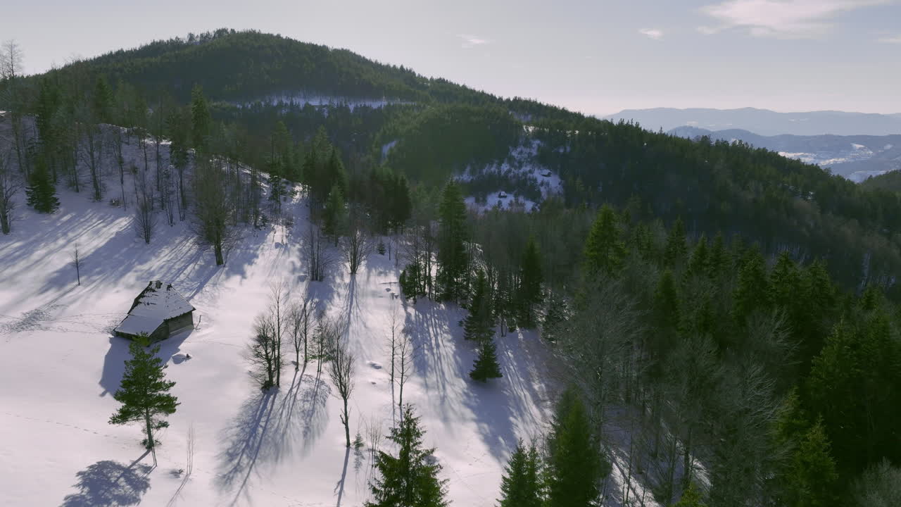 Snowy Mountain Landscape with Forest and Rustic Cabin