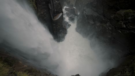 dangerous strong current of water flowing through pailon del diablo waterfall in baños de agua santa, ecuador