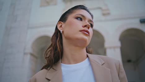 portrait fashion model posing at urban building looking away. beautiful girl