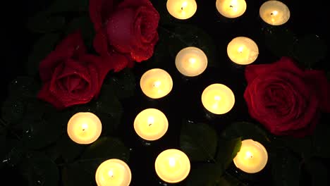 roses and candles on a black background.