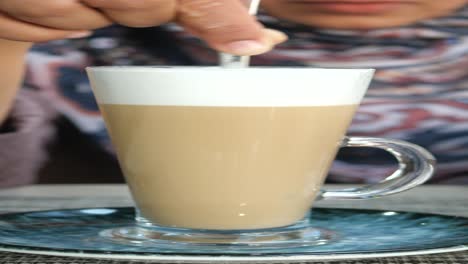 persona que agita un latte