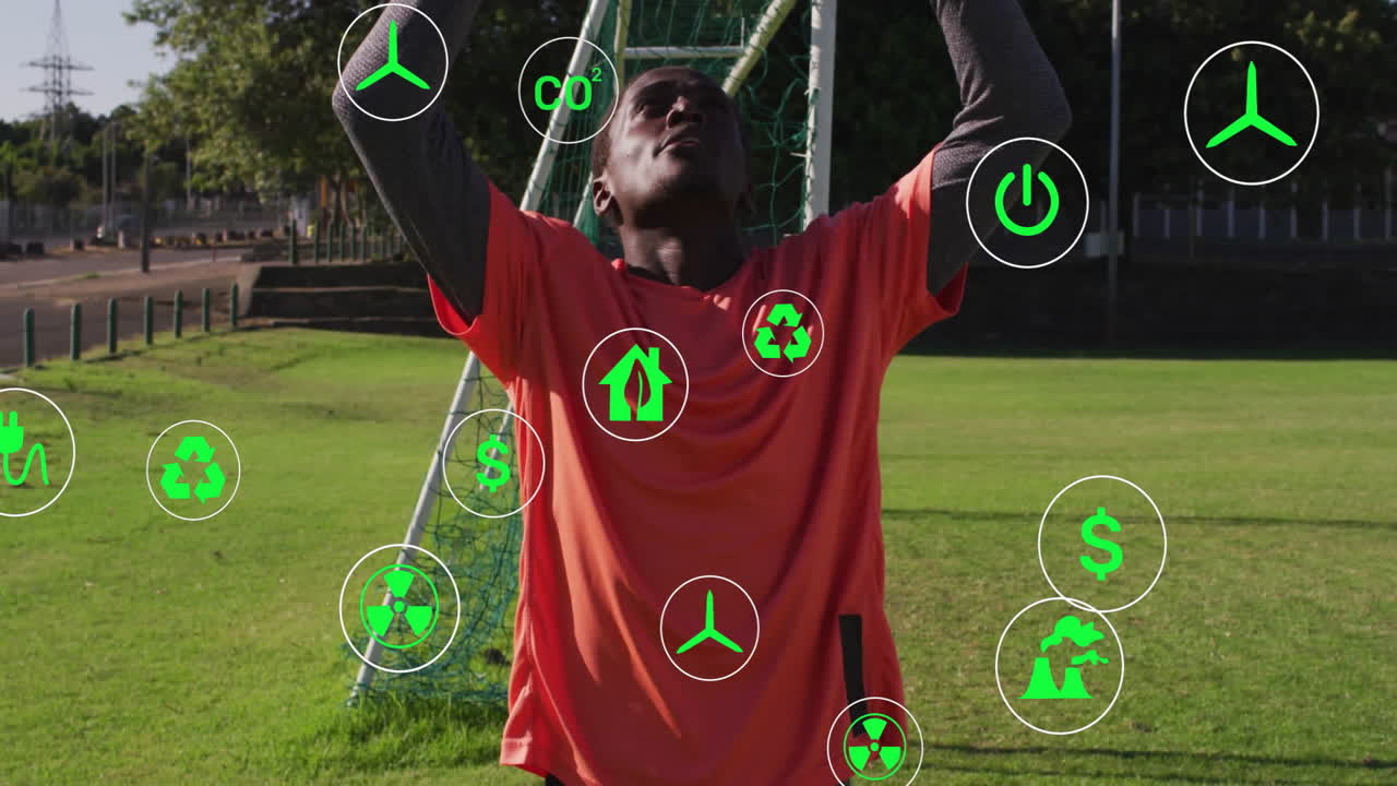 Catching soccer ball, player with animation of green environmental icons on field