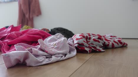 a messy pile of clothes on the floor in a bedroom