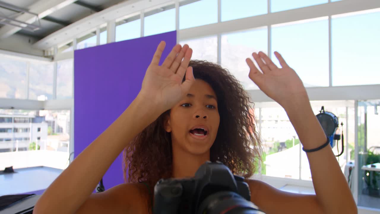 Model holding camera in photo studio 4k