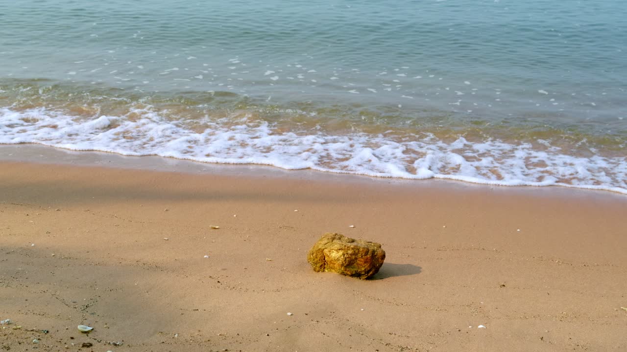 A solitary stone a serene beach capturing the tranquility of nature's beauty by the gentle waves.
